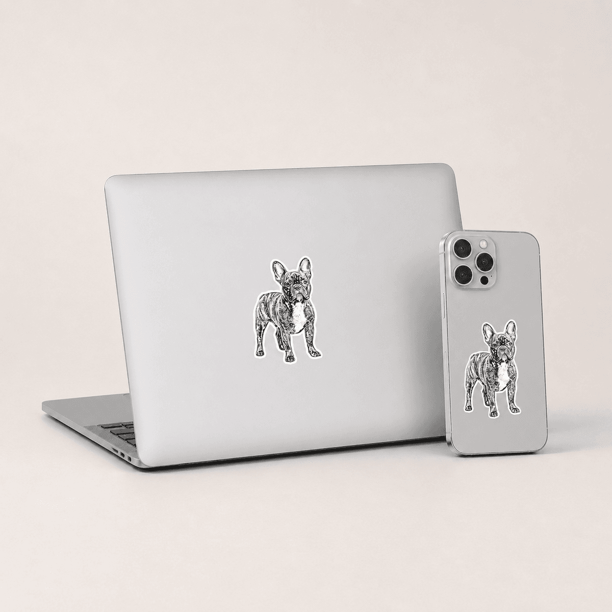 Custom dog stickers on a MacBook and iPhone